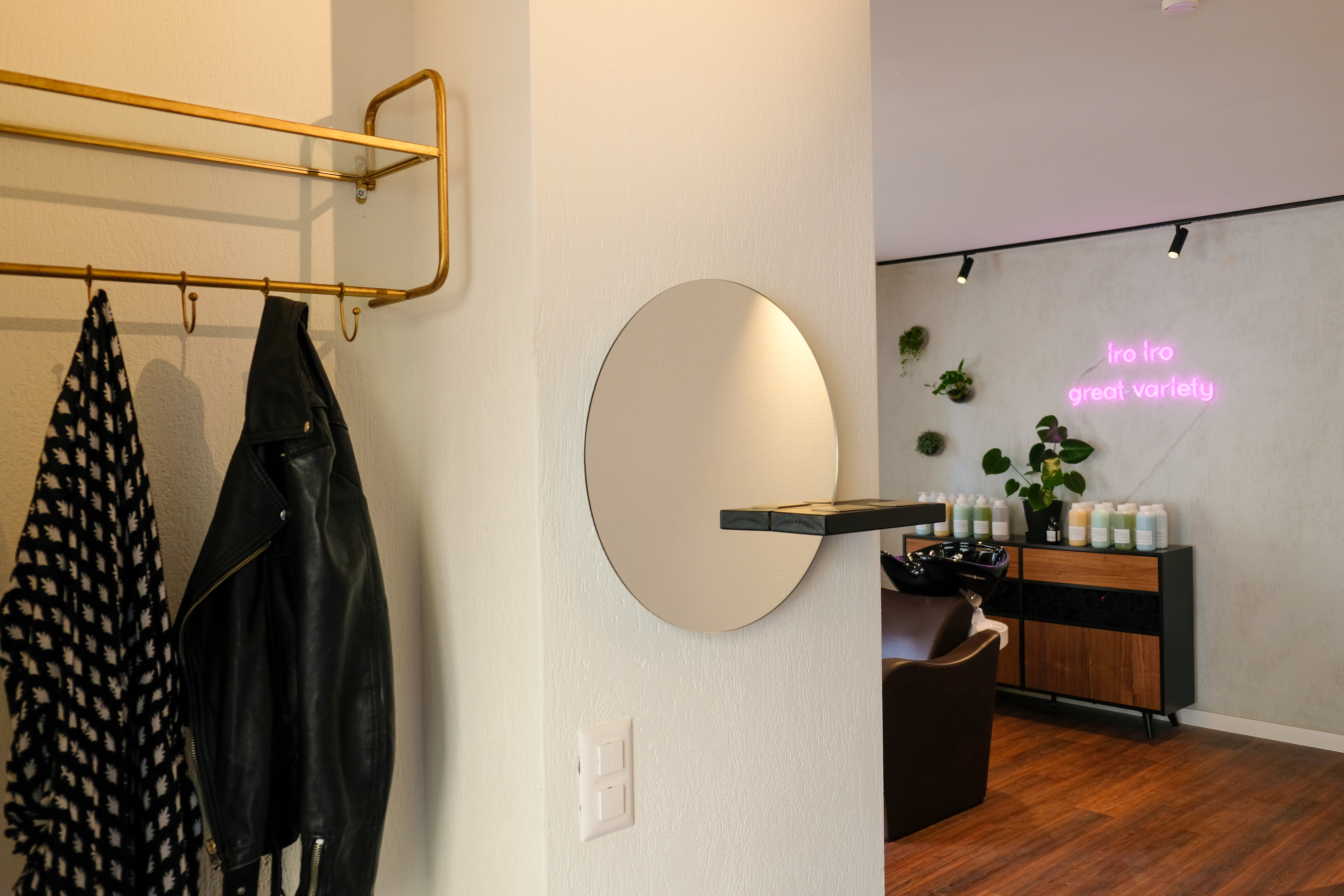Salon entrance with coat rack and neon sign